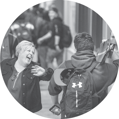 Rogers High School Principal Lori Wyborney greets freshman Elliot Septa in the hallway between classes, Friday, Dec, 15, 2017  She's credited for climbing graduation rates and turning around the culture at Rogers High School 